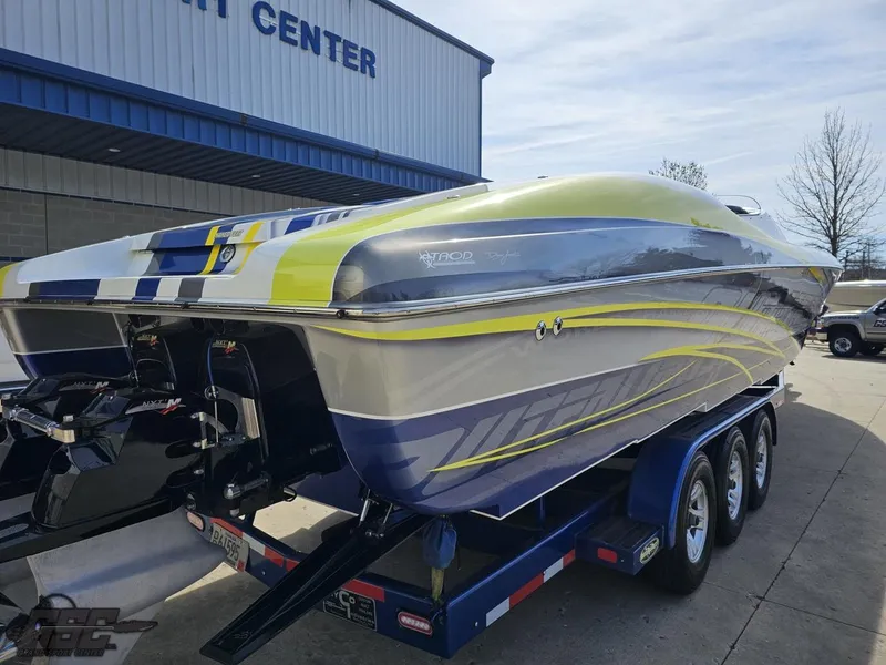 Slide: The Image of 2007 Outerlimits 39 Quattro powerboat on trailer, vibrant design, parked outside service center. - 27