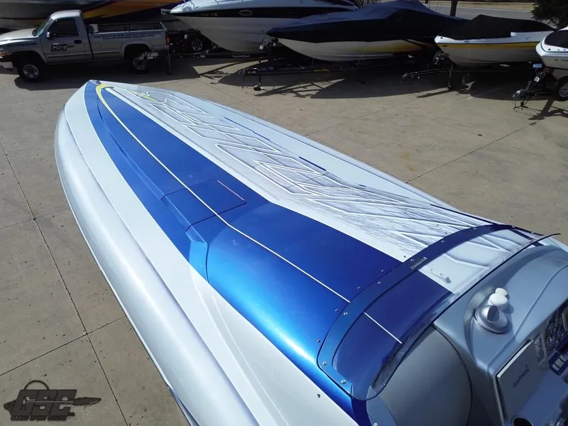 Slide: The Image of 2007 Outerlimits 39 Quattro speedboat with sleek blue and white design, parked on concrete. - 35