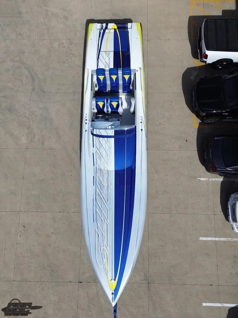 Slide: The Image of 2007 Outerlimits 39 Quattro speedboat with blue and white design, parked beside cars. - 41