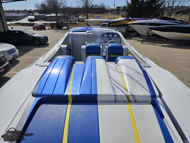 Slide: The Image of 2007 Outerlimits 39 Quattro boat with blue, white, and yellow seating in a marina setting. - 43