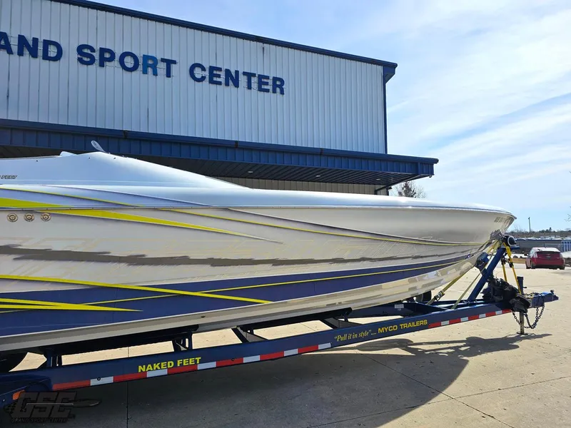 Slide: The Image of 2007 Outerlimits 39 Quattro boat on trailer outside a sport center. - 5