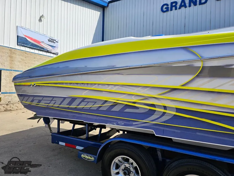Slide: The Image of 2007 Outerlimits 39 Quattro boat with vibrant yellow and blue detailing on a trailer. - 7