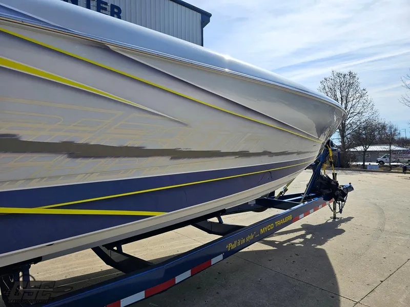 Slide: The Image of 2007 Outerlimits 39 Quattro boat on trailer, sleek design with blue and yellow accents. - 9