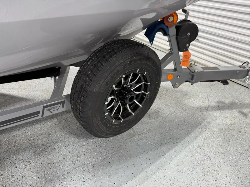 Slide: The Image of 2025 MasterCraft ProStar trailer with black alloy wheel and hitch in a garage. - 12