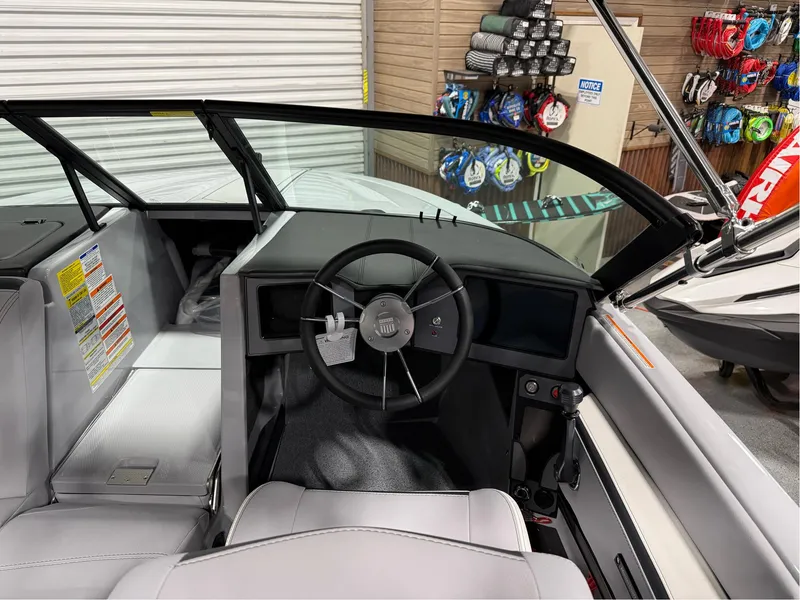 Slide: The Image of 2025 MasterCraft ProStar boat interior with steering wheel and dashboard in showroom. - 15
