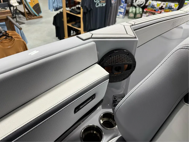 Slide: The Image of 2025 MasterCraft ProStar interior with speaker and cup holders in a showroom. - 19