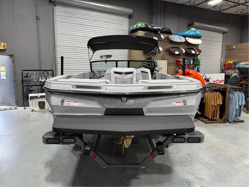 Slide: The Image of 2025 MasterCraft ProStar boat in showroom, rear view with accessories displayed. - 4