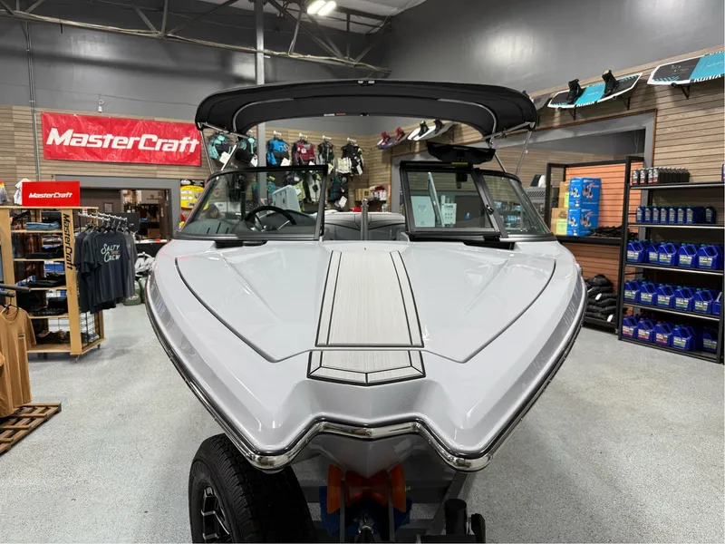 Slide: The Image of 2025 MasterCraft ProStar boat displayed in showroom with branded merchandise. - 8