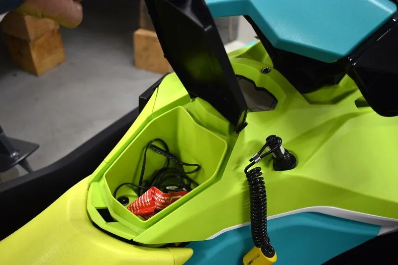 Slide: The Image of 2022 Sea-Doo Spark® 3-up storage compartment with accessories and vibrant color scheme. - 17