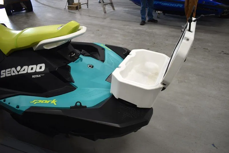 Slide: The Image of 2022 Sea-Doo Spark 3-up Rotax 900 ACE with storage compartment open in a garage. - 20