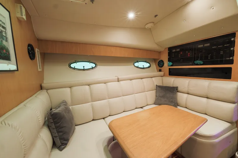 Slide: The Image of 1998 Tiara Yachts 3500 Open interior with beige seating and wooden table. - 1