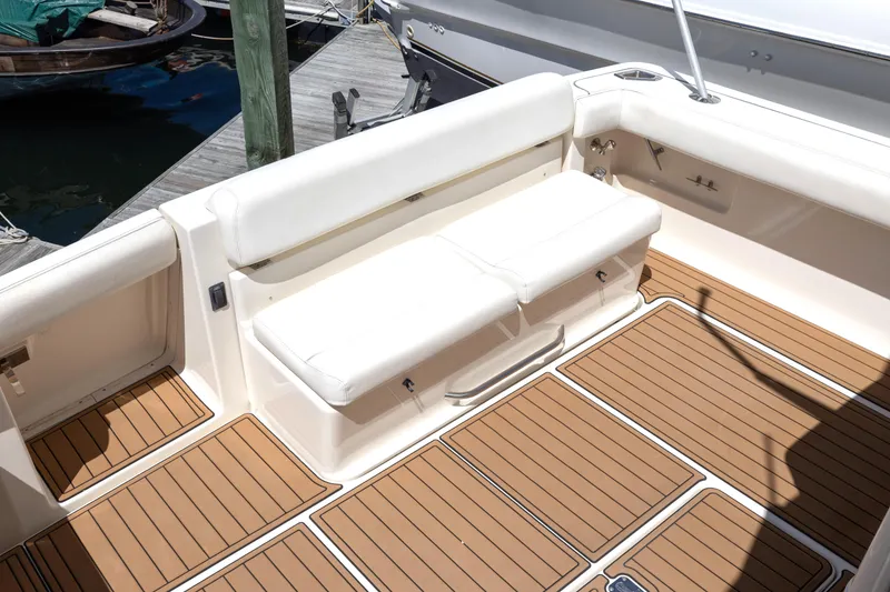 Slide: The Image of 1998 Tiara Yachts 3500 Open boat interior with white seating and teak flooring. - 8