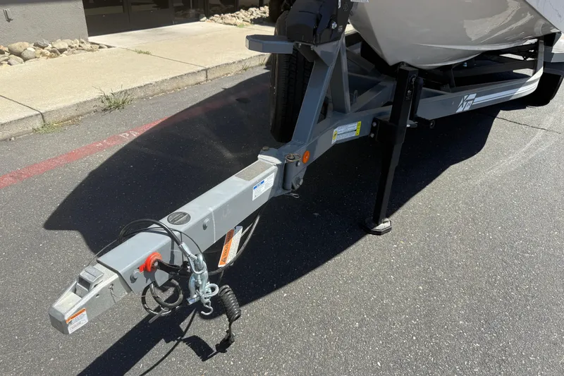 Slide: The Image of 2025 MasterCraft XT24 boat trailer hitch on pavement, showcasing sturdy construction. - 10