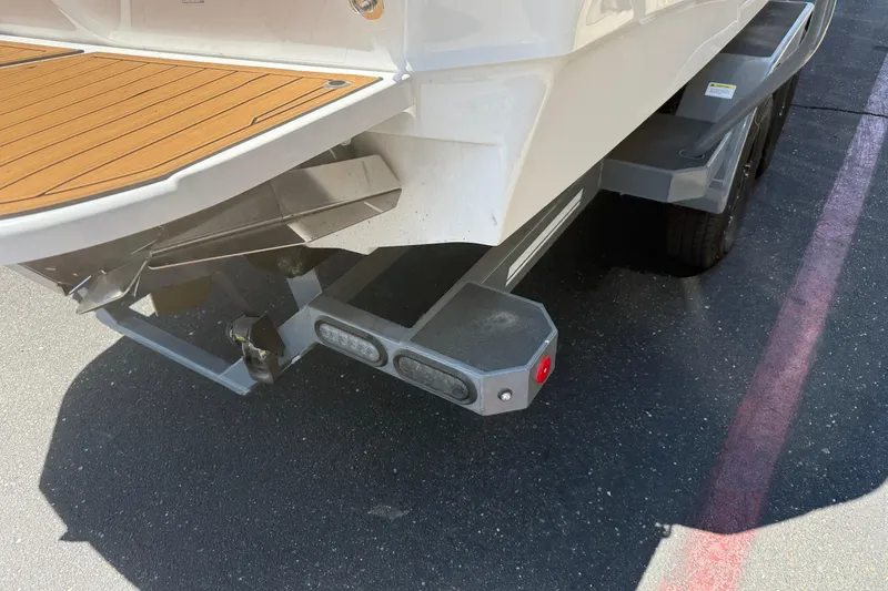 Slide: The Image of Rear view of 2025 MasterCraft XT24 boat on trailer, showcasing propeller and swim platform. - 13