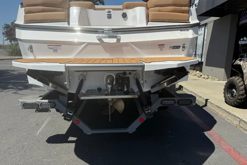 Slide: The Image of 2025 MasterCraft XT24 boat rear view with teak swim platform and propeller. - 14