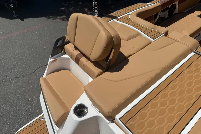Slide: The Image of 2025 MasterCraft XT24 boat interior with tan seating and cup holder. - 16