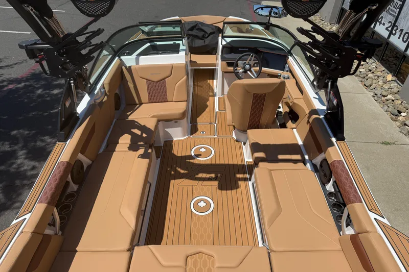 Slide: The Image of 2025 MasterCraft XT24 boat interior with tan seating and modern dashboard design. - 18