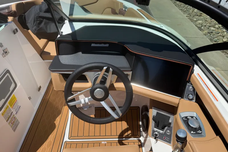 Slide: The Image of 2025 MasterCraft XT24 boat cockpit with modern steering and control panel. - 19