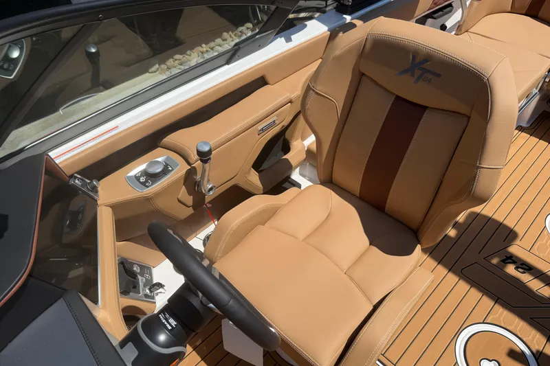 Slide: The Image of 2025 MasterCraft XT24 boat interior with tan leather seating and modern controls. - 21