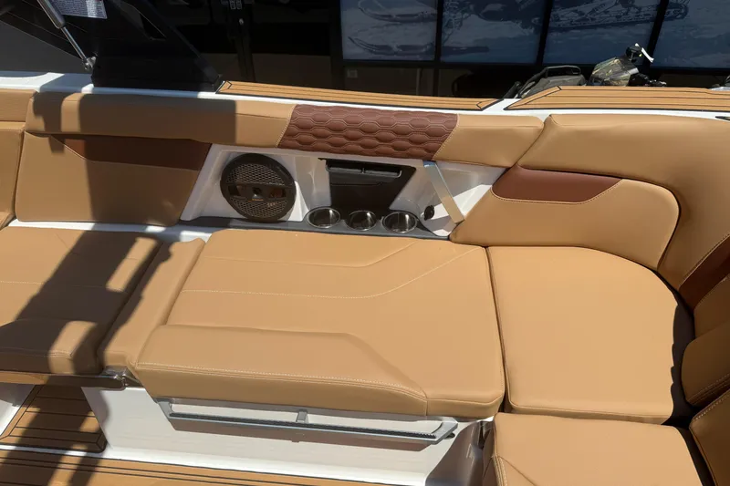 Slide: The Image of 2025 MasterCraft XT24 boat interior with tan leather seating and built-in speaker. - 23