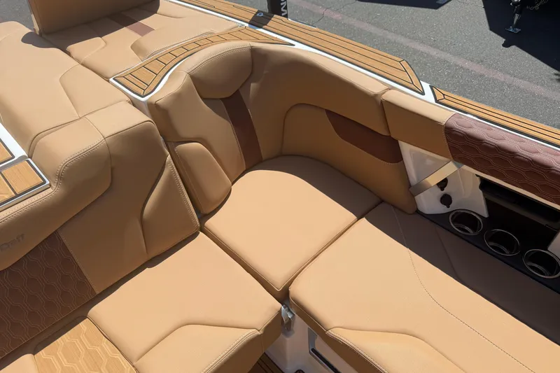 Slide: The Image of 2025 MasterCraft XT24 boat interior with tan leather seating and cup holders. - 26