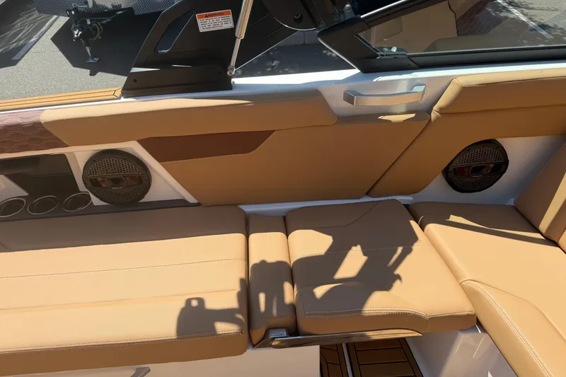 Slide: The Image of 2025 MasterCraft XT24 boat interior with tan leather seating and built-in speakers. - 28