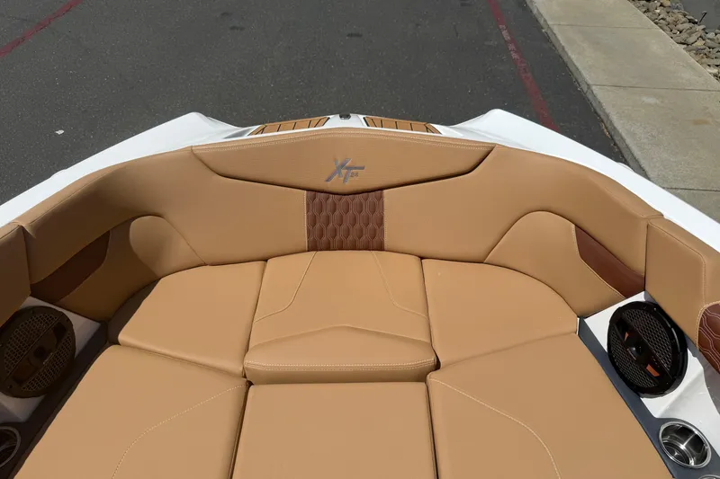 Slide: The Image of 2025 MasterCraft XT24 boat interior with tan upholstery and speaker system. - 33