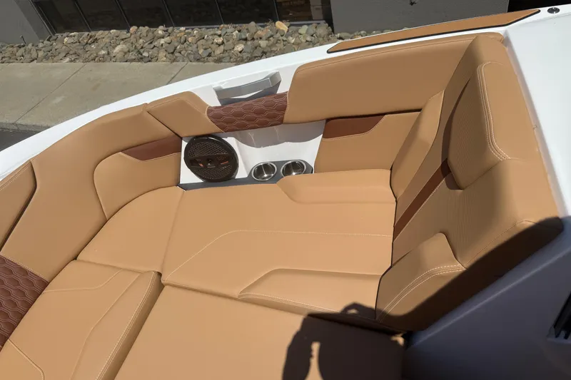 Slide: The Image of 2025 MasterCraft XT24 boat interior with tan leather seating and built-in speaker. - 34