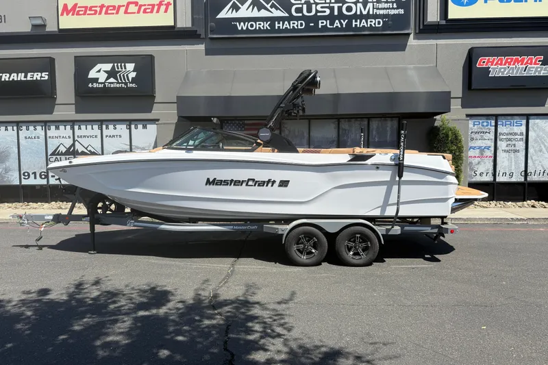 Slide: The Image of 2025 MasterCraft XT24 boat on trailer, parked outside dealership. - 4