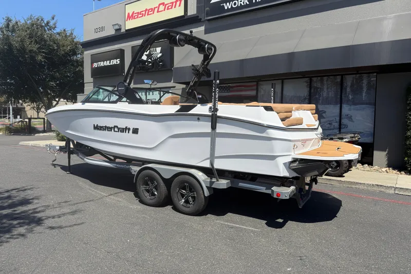 Slide: The Image of 2025 MasterCraft XT24 boat on trailer outside dealership. - 5