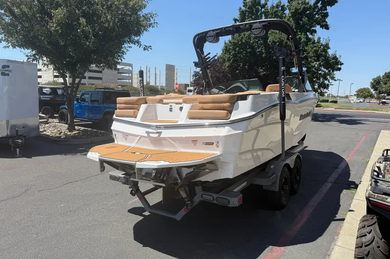 Slide: The Image of 2025 MasterCraft XT24 boat on trailer in parking lot, rear view. - 7