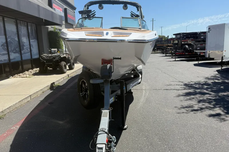 Slide: The Image of 2025 MasterCraft XT24 boat on trailer in outdoor dealership lot. - 9