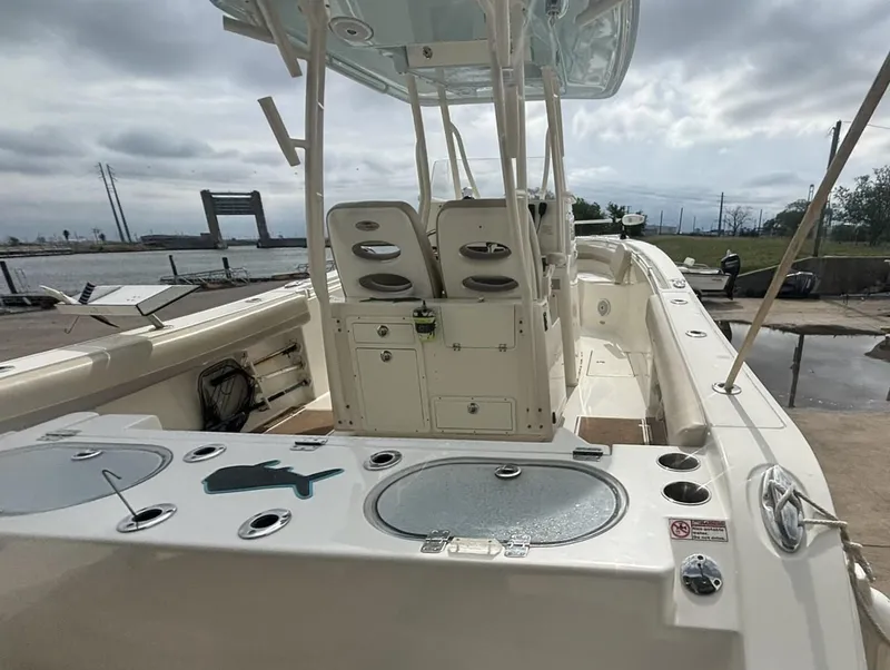 Slide: The Image of 2017 Cobia 296 Center Console boat docked, featuring spacious seating and fishing amenities. - 13