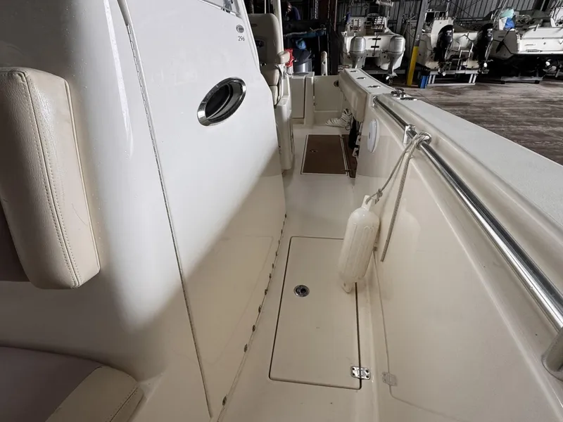 Slide: The Image of 2017 Cobia 296 Center Console boat interior with white seating and storage compartments. - 16