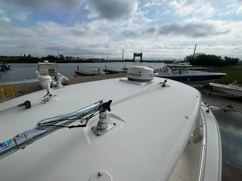 Slide: The Image of 2017 Cobia 296 Center Console boat docked by a calm waterfront. - 19