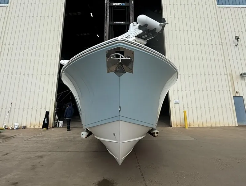 Slide: The Image of 2017 Cobia 296 Center Console boat in front of a large warehouse. - 2