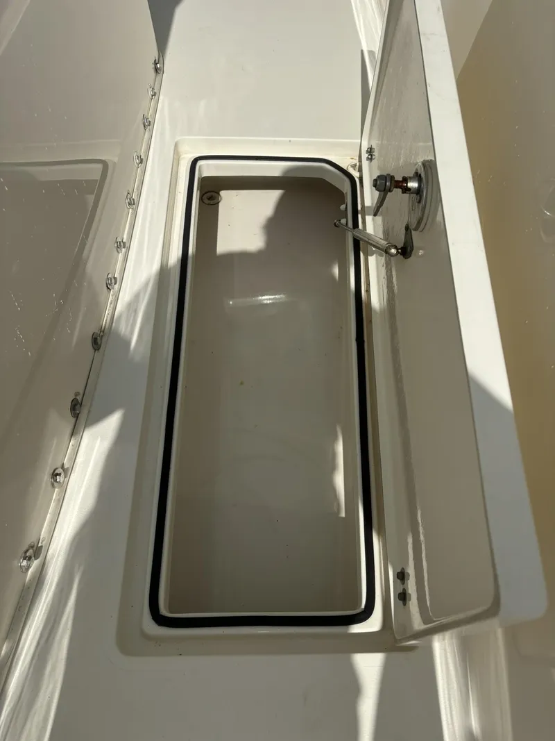 Slide: The Image of 2017 Cobia 296 Center Console storage compartment with open lid. - 22