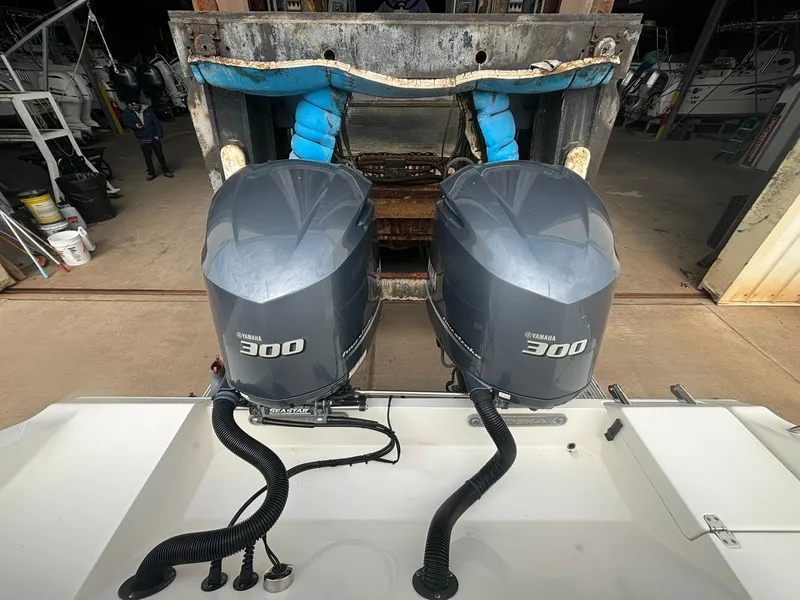 Slide: The Image of 2017 Cobia 296 Center Console with twin Yamaha 300 engines in a boatyard. - 23