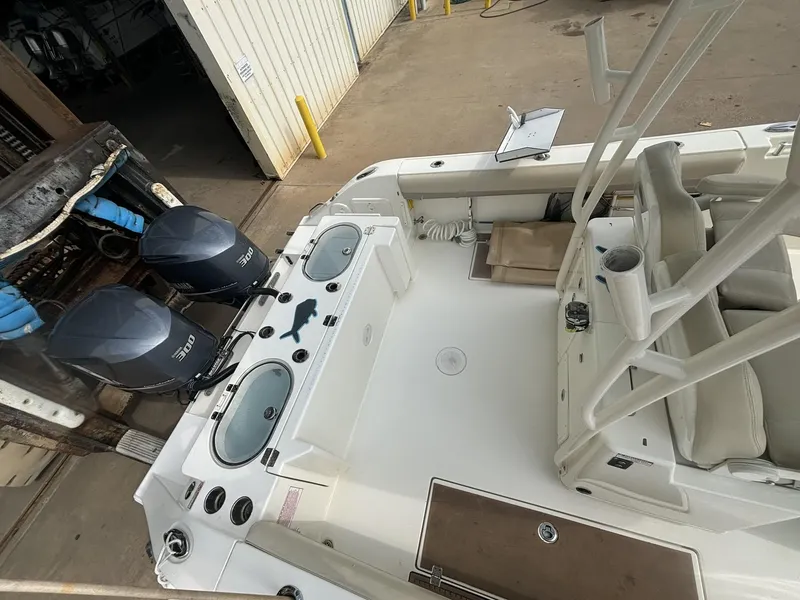 Slide: The Image of 2017 Cobia 296 Center Console boat with dual engines, docked in a marina. - 26