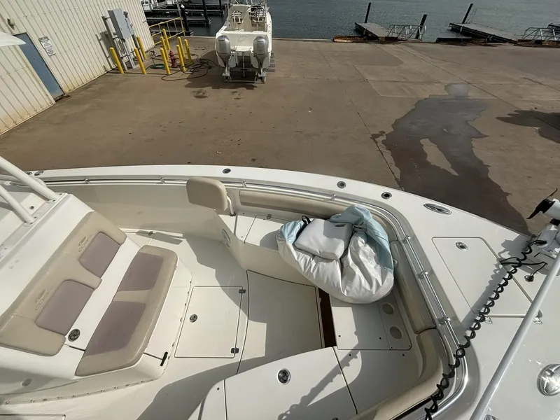 Slide: The Image of 2017 Cobia 296 Center Console boat docked, featuring spacious seating and storage area. - 27