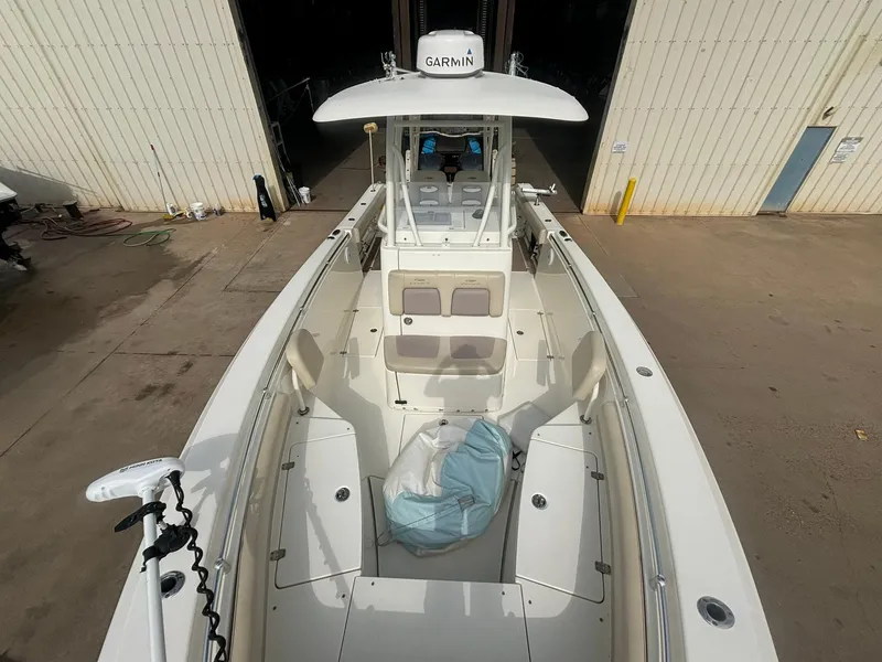 Slide: The Image of 2017 Cobia 296 Center Console boat docked, featuring spacious deck and Garmin equipment. - 32