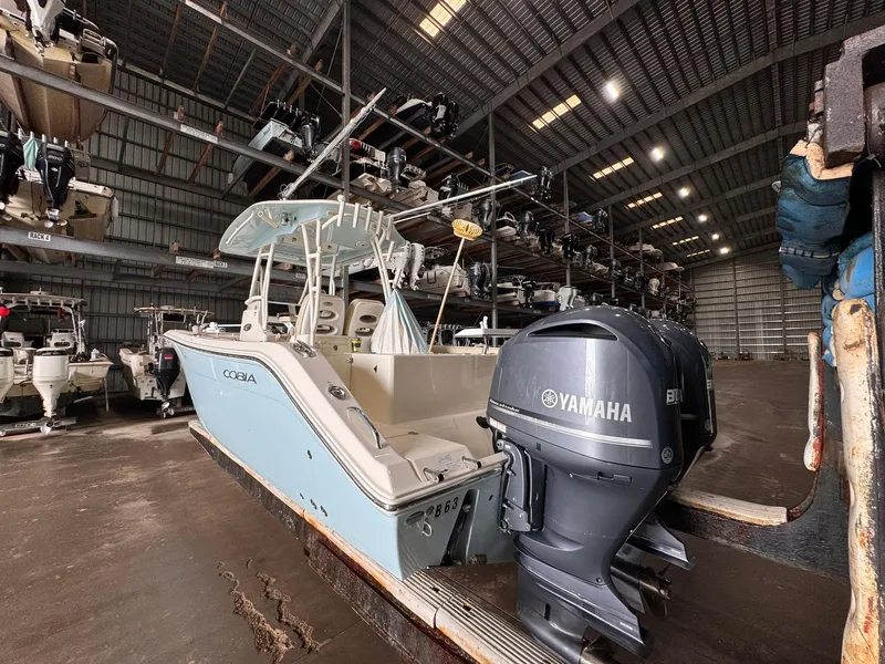 Slide: The Image of 2017 Cobia 296 Center Console boat with Yamaha engines in a storage facility. - 35