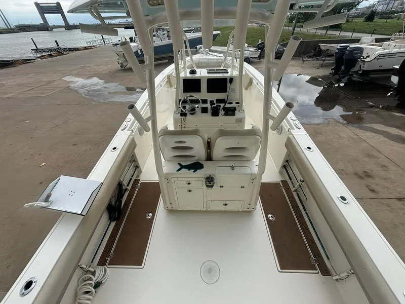 Slide: The Image of 2017 Cobia 296 Center Console boat docked, featuring spacious deck and dual seating. - 4