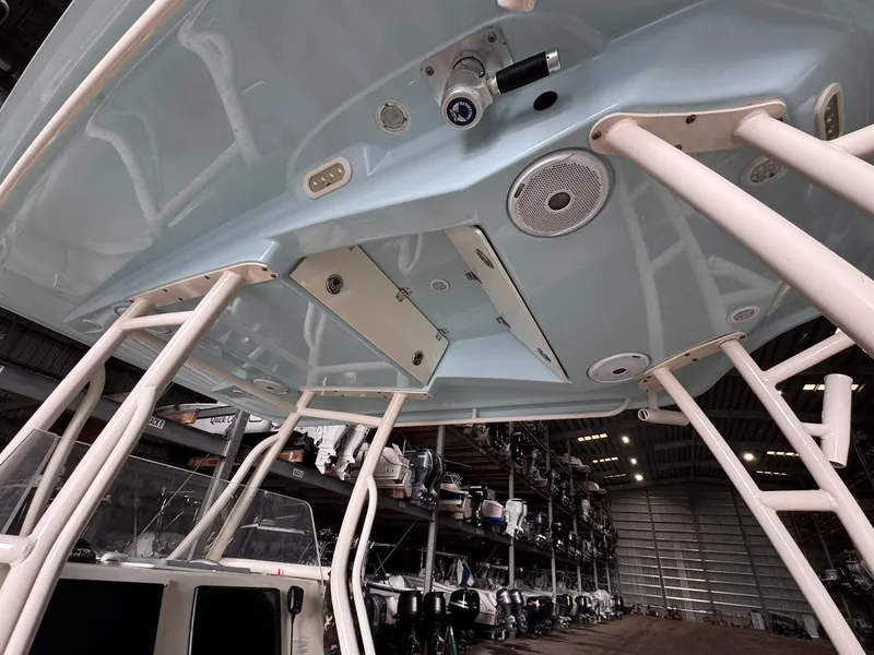 Slide: The Image of 2017 Cobia 296 Center Console boat interior, showcasing overhead design and storage in a warehouse. - 42