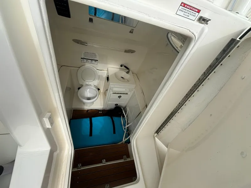 Slide: The Image of 2017 Cobia 296 Center Console boat interior with toilet and storage area. - 44