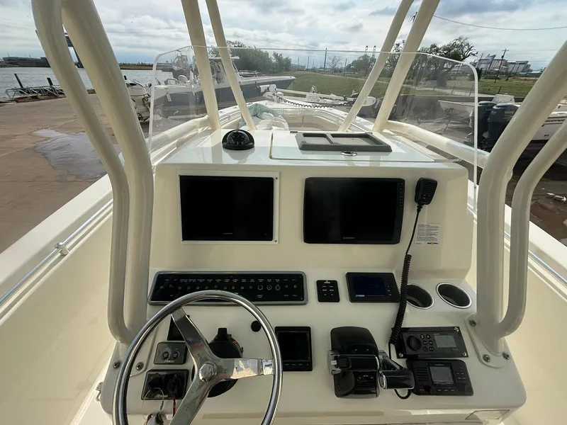 Slide: The Image of 2017 Cobia 296 Center Console boat dashboard with steering wheel and navigation screens. - 7