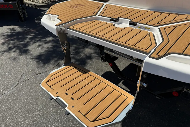 Slide: The Image of 2025 MasterCraft XT24 swim platform with teak-style decking, showcasing modern design. - 16
