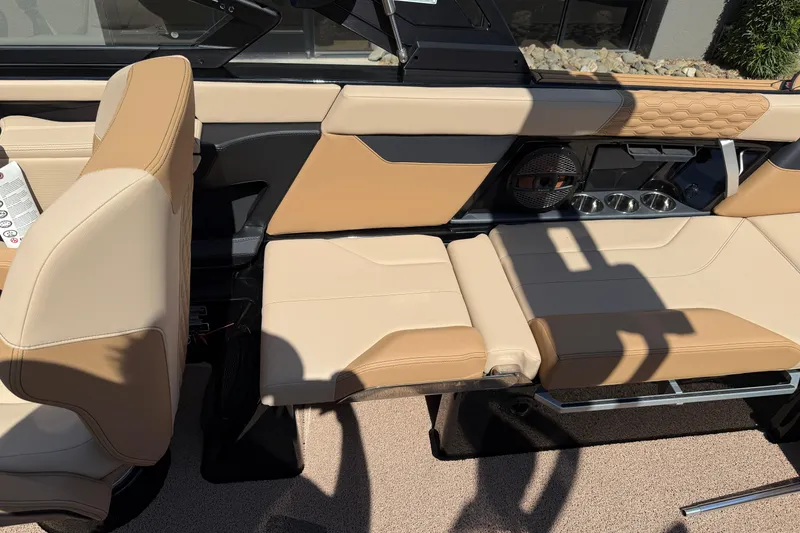 Slide: The Image of 2025 MasterCraft XT24 boat interior with tan leather seating and cup holders. - 24