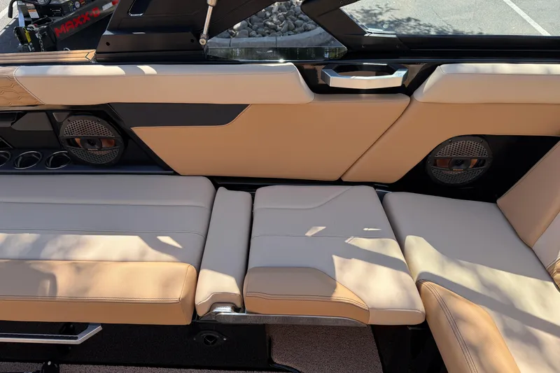 Slide: The Image of 2025 MasterCraft XT24 boat interior with beige seating and built-in speakers. - 30