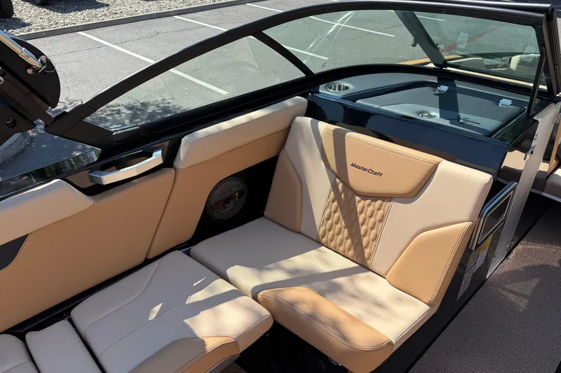 Slide: The Image of 2025 MasterCraft XT24 boat interior with beige leather seating and modern design. - 31